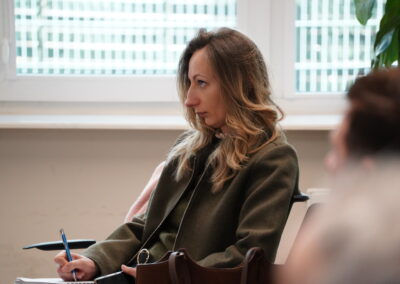 Uczestniczka spotkania notuje podczas debaty eksperckiej w sali konferencyjnej