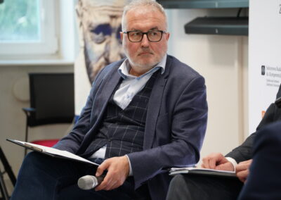 Ekspert w okularach słucha wypowiedzi podczas panelu dyskusyjnego