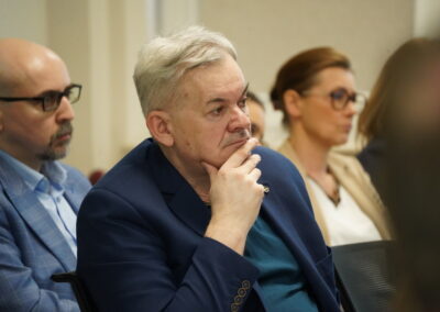 Uczestnicy spotkania słuchają panelu dyskusyjnego w sali konferencyjnej.