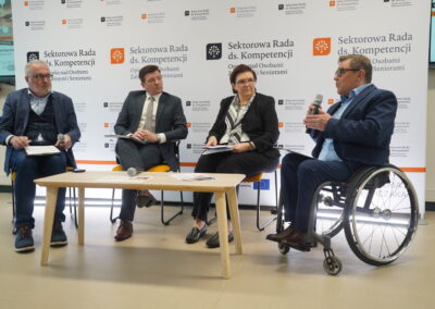 Prelegent w granatowej marynarce przemawia przy mównicy na tle baneru projektu.