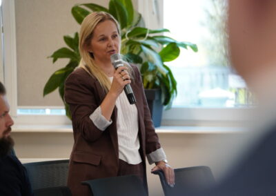 Uczestnik spotkania zadaje pytanie podczas panelu dyskusyjnego w sali konferencyjnej